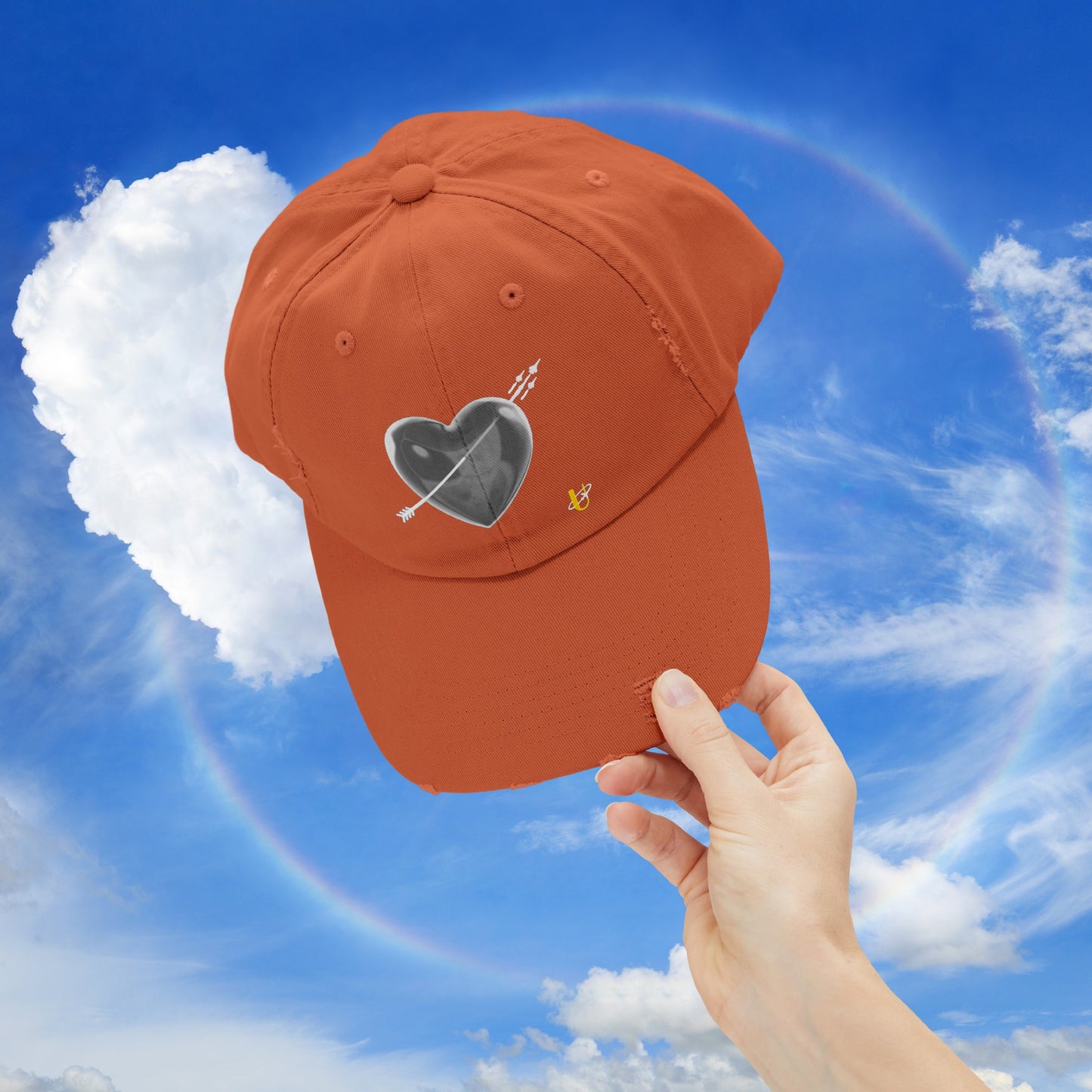 burnt orange "Love Jet" hat being held up in the sky